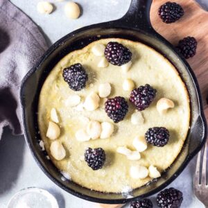 Keto Dutch Baby in skillet with blackberries and macadamia nuts