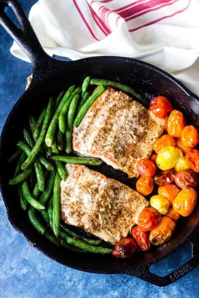 Salmon with Burst Tomatoes and Green Beans in cast iron skillet on table