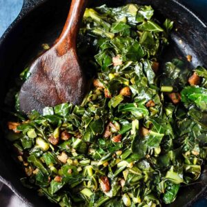 Spicy Pork Belly Collard Greens in skillet with wooden spoon