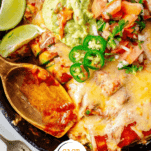 Keto Enchiladas in a cast iron skillet topped with jalapenos, guacamole, and pico de gallo