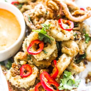 Keto Calamari in a tray with sliced peppers and a dipping sauce