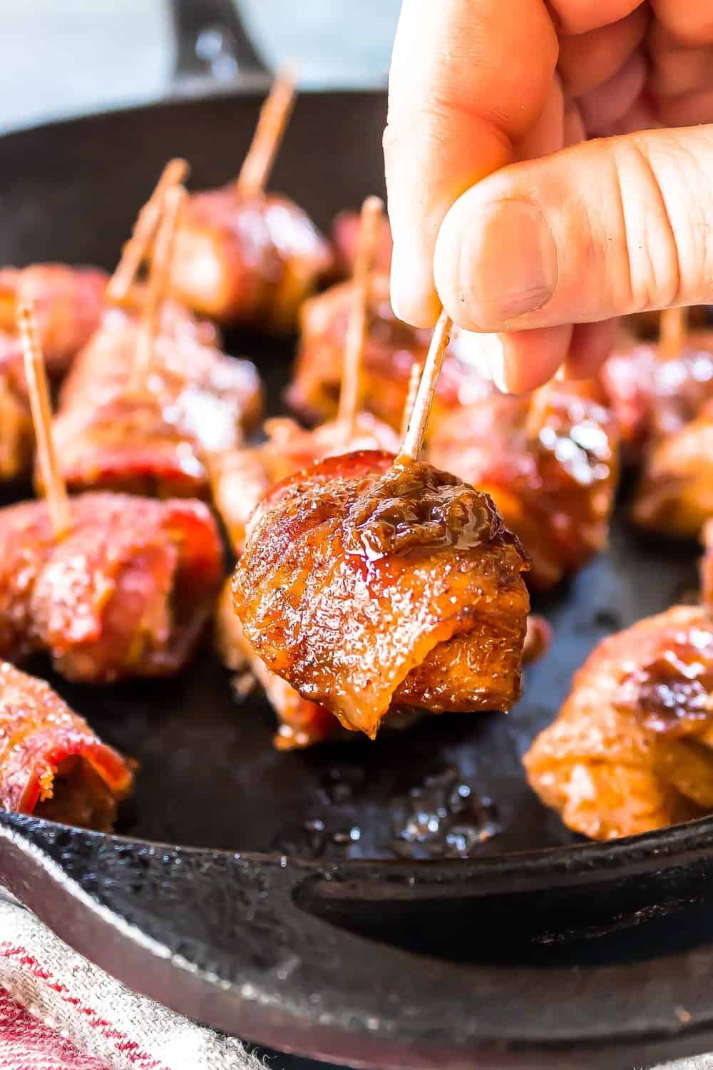 Keto Bacon Brown Sugar Chicken Bites with one being picked up with a toothpick