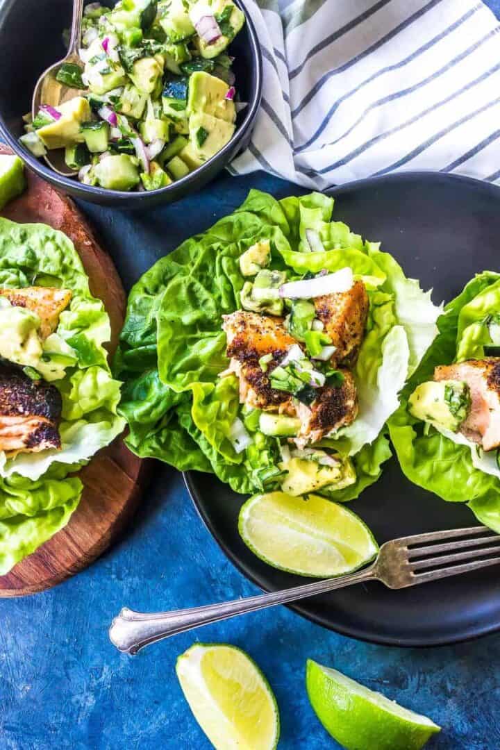 Keto Fish Tacos on a black plate with a small bowl of salsa mixed together off to the side