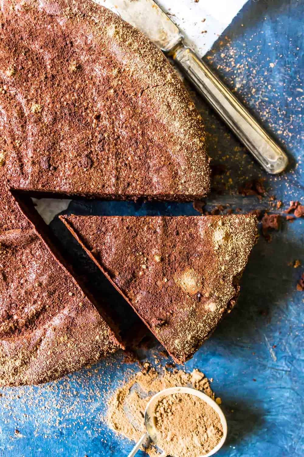 Chocolate torte with a single slice cut out and slide away from the center of the torte.