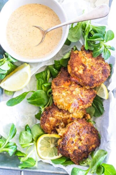 Keto Crab Cakes in tray with sliced lemons and sauce