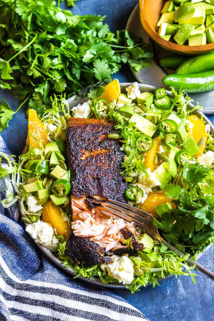 Cajun Salmon with Avocado Orange Salad o n a blue background