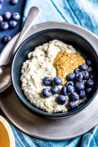 keto oatmeal in a bowl topped with blueberries and almond butter