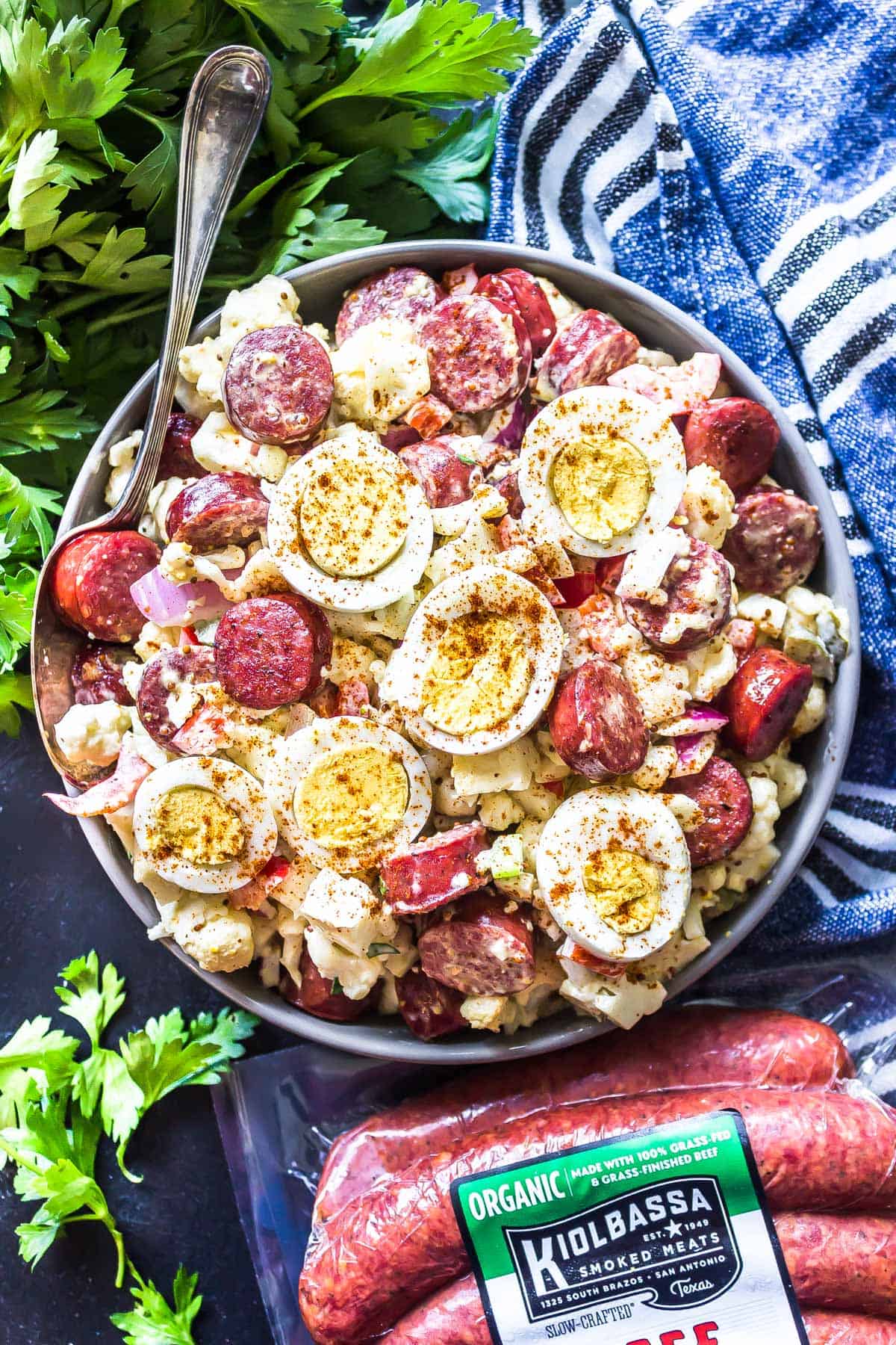 Keto "Potato" Salad with Smoked Sausage In a large serving bowl with kiolbassa packaging in the foreground.