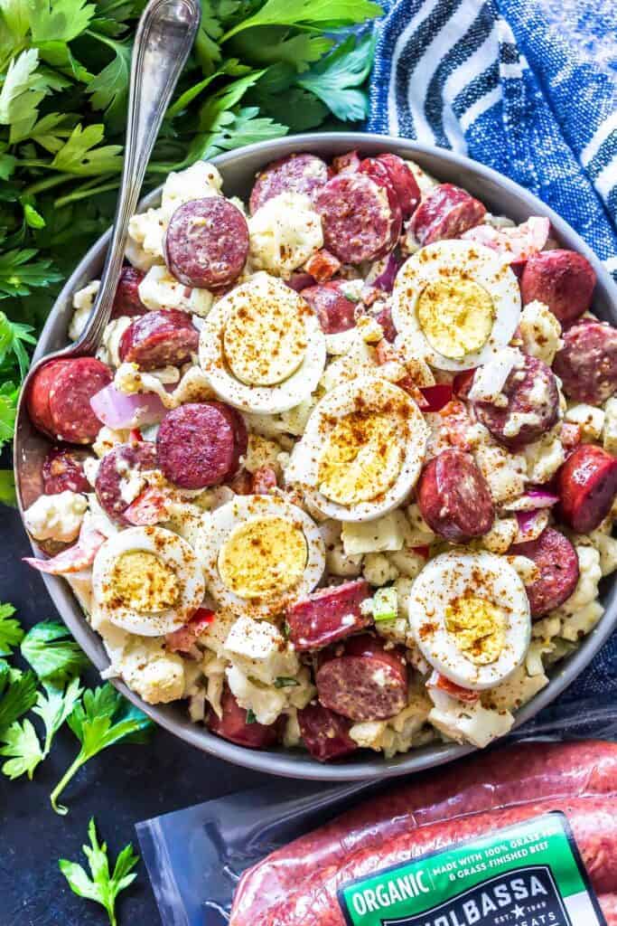 Keto "Potato" Salad with Smoked Sausage In a large serving bowl with kiolbassa packaging in the foreground.