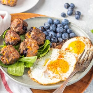 Keto Breakfast Meatballs on plate with eggs and blueberries