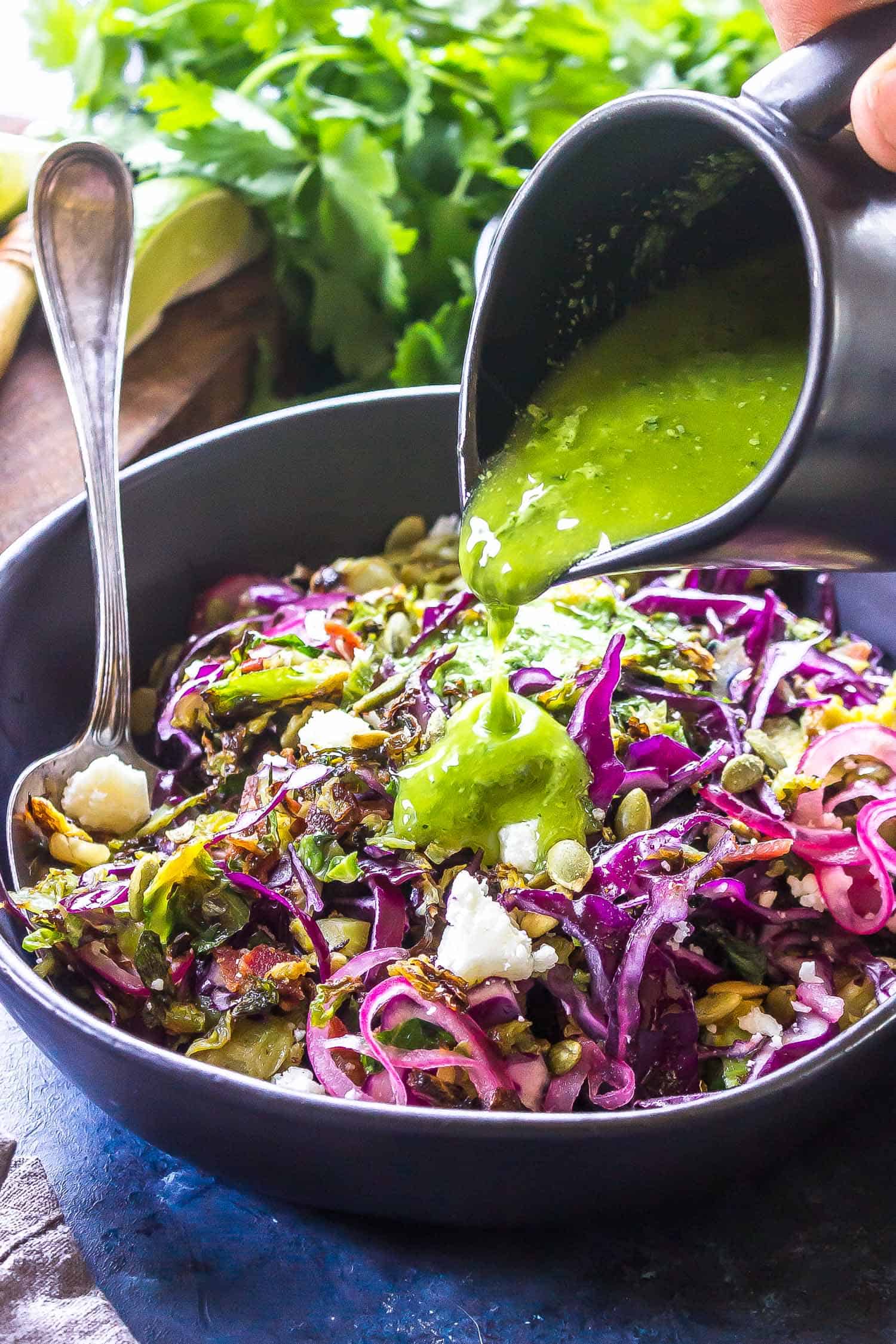 Keto Charred Brussels Sprout Salad with Creamy Cilantro Dressing being drizzled over top