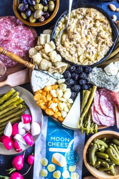 How To Build a Keto Cheese Board featured image with a huge spread of different cheeses, dips, crackers/pork rinds, veggies and berries
