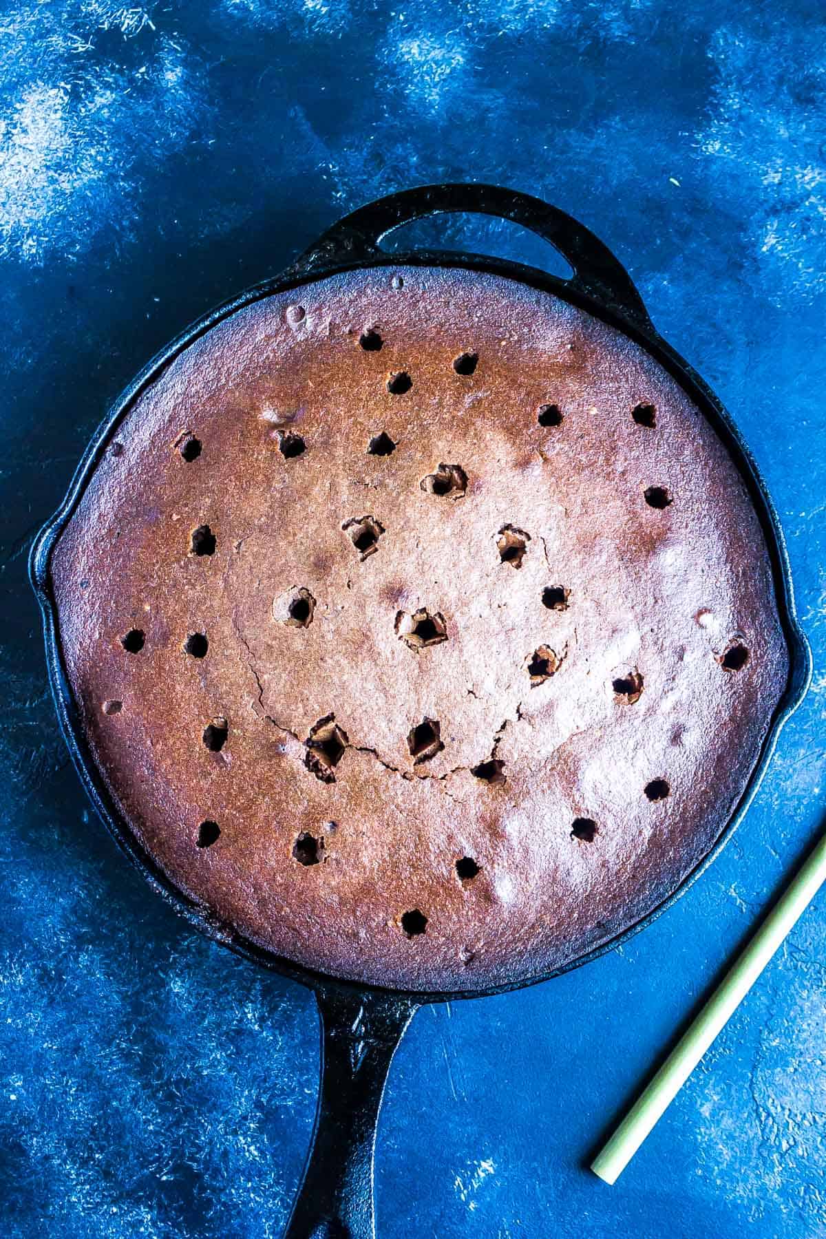 Chocolate Cake after being baked with holes poked into it.
