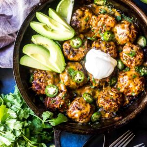 Keto Enchilada Meatball Skillet in skillet with avocado and sour cream on top