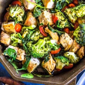 Close up: Keto Italian Chicken Skillet (cubed chicken, broccoli, cherry tomatoe and sauce) in a finex cast iron skillet.