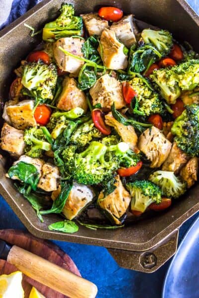 Close up: Keto Italian Chicken Skillet (cubed chicken, broccoli, cherry tomatoe and sauce) in a finex cast iron skillet.