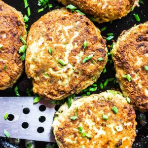 Keto Salmon Patties cooked in skillet with chives on top