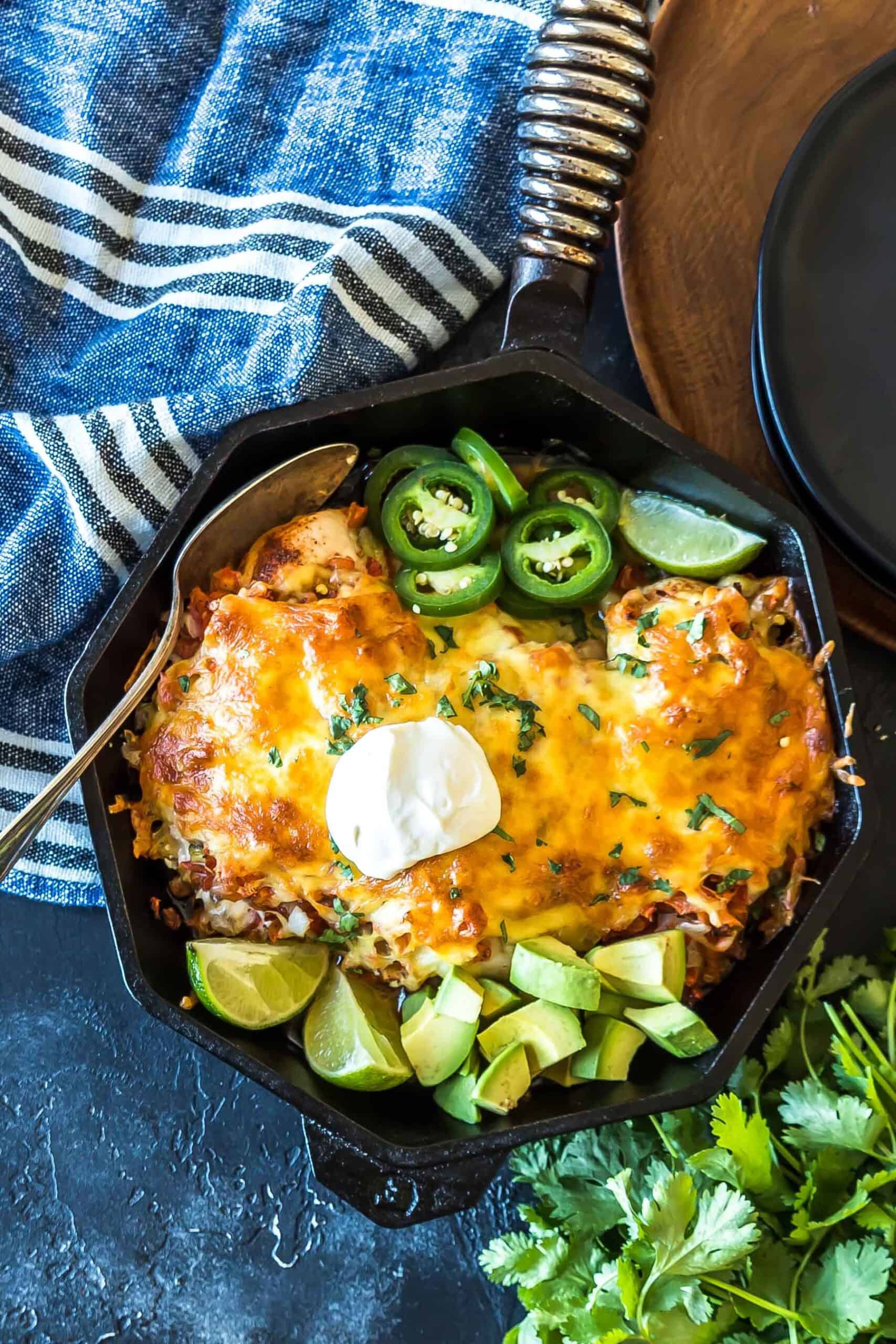 overhead shot, keto salsa chicken bake fresh from oven with toppings served in a cast iron skillet.