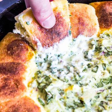 Keto Spinach Artichoke Dip Pull Apart Rolls with one being pulled out of skillet