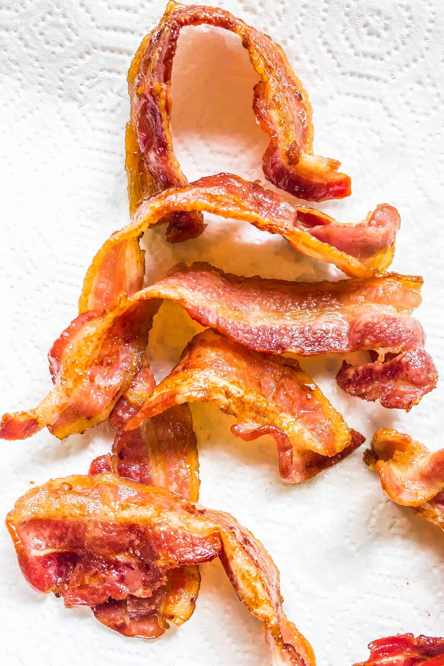 crispy oven cooked bacon on a paper towel lined plate