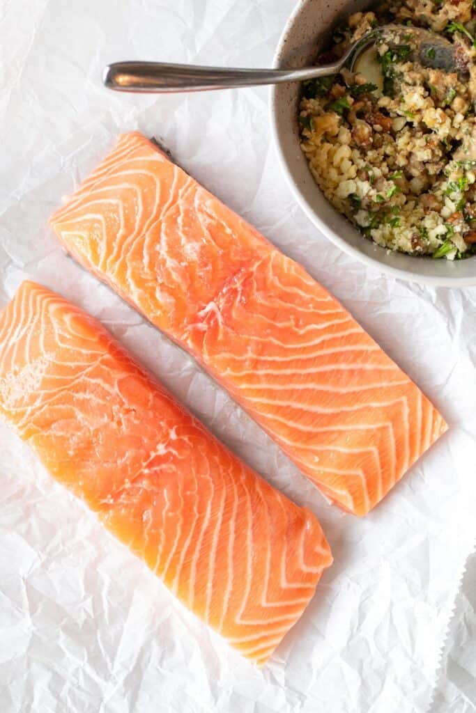 raw salmon fillets on parchment paper