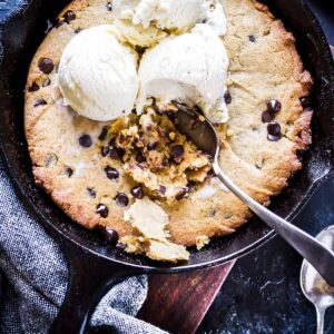Keto Browned Butter Skillet Chocolate Chip Cookie in a small cast iron skillet topped with vanilla ice cream.