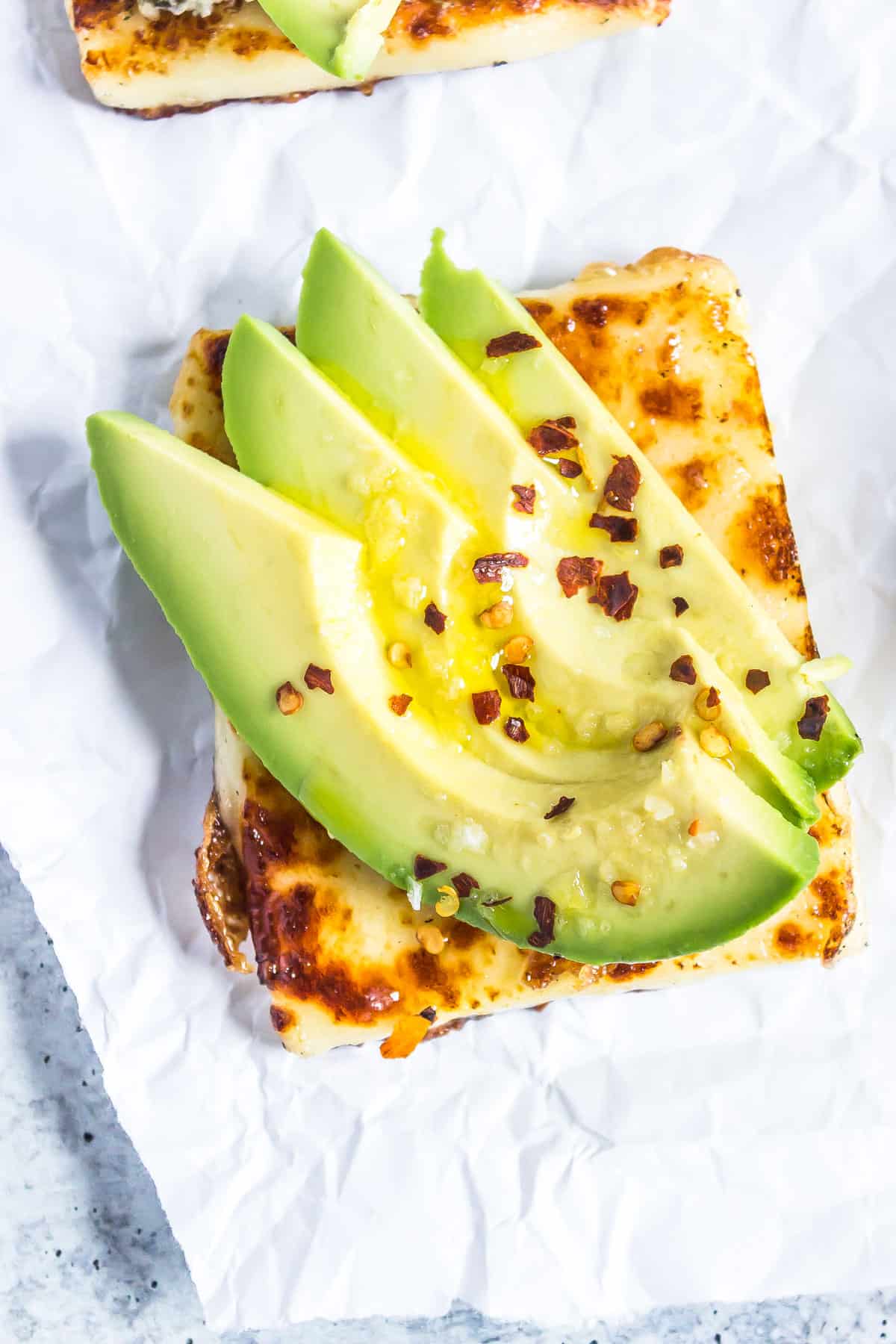 simple avocado, salt, and red pepper flakes on bread cheese