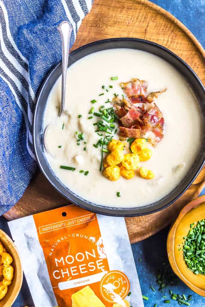 Loaded Keto Turnip Soup in a black Bowl on a wooden platter