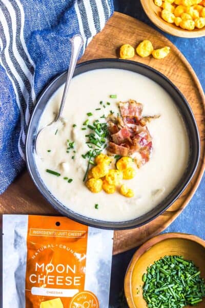 Loaded Keto Turnip Soup in a black bowl on a wooden platter
