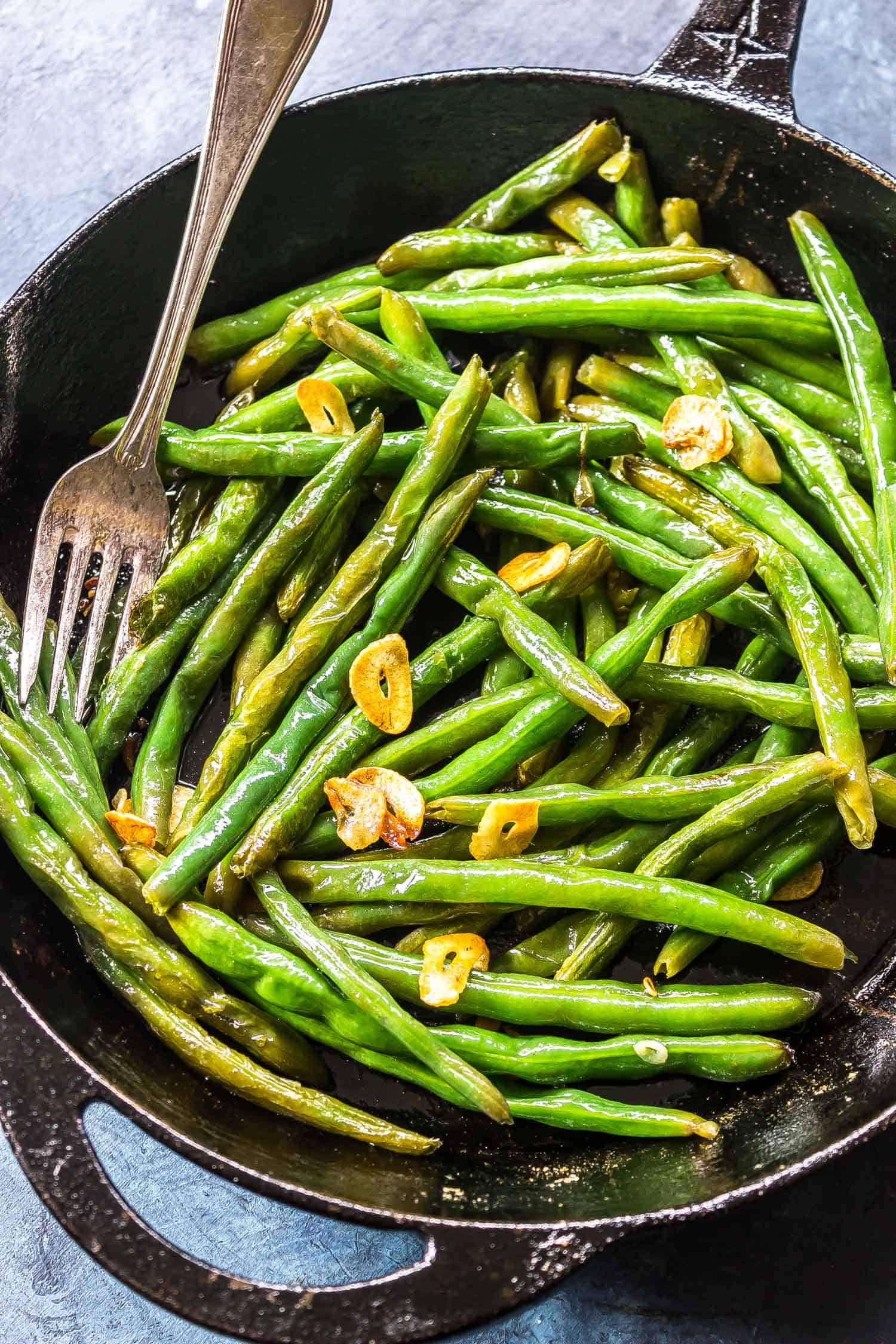 Garlic Butter Green Beans in a cast iron skillet with a serving fork