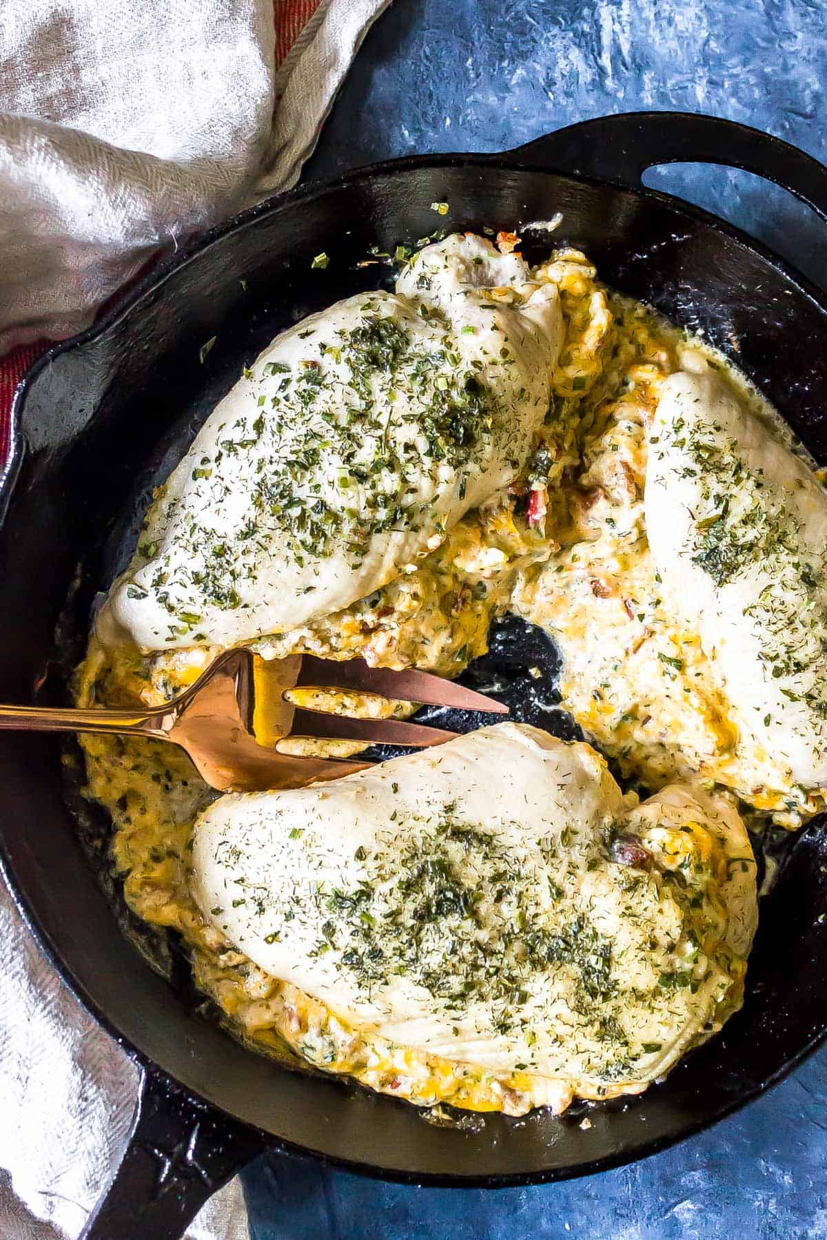 3 Keto Crack Dip Stuffed Chicken Breasts in a cast iron skillet