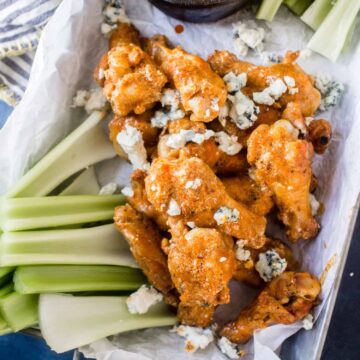 keto chicken wings in tray with buffalo blue cheese sauce and celery