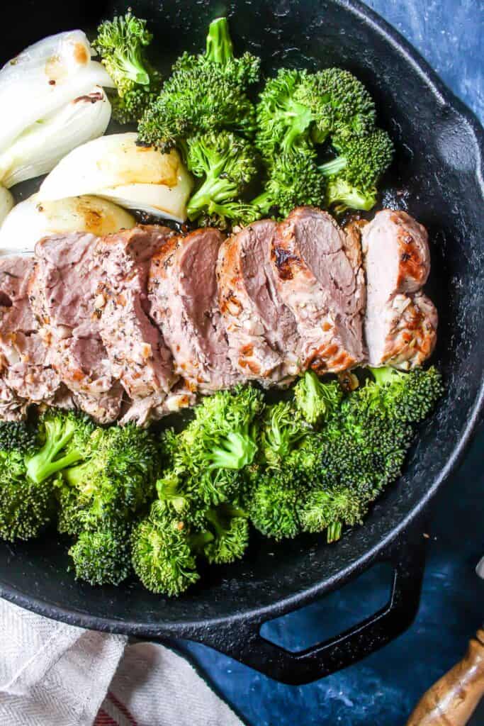 Keto Pork Tenderloin Skillet Dinner. Pork tenderloing, broccoli, and onions in a skillet.