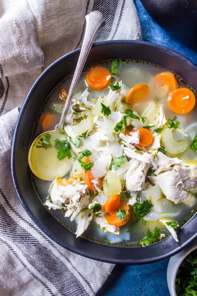 Keto Chicken Soup in a black bowl with a spoon