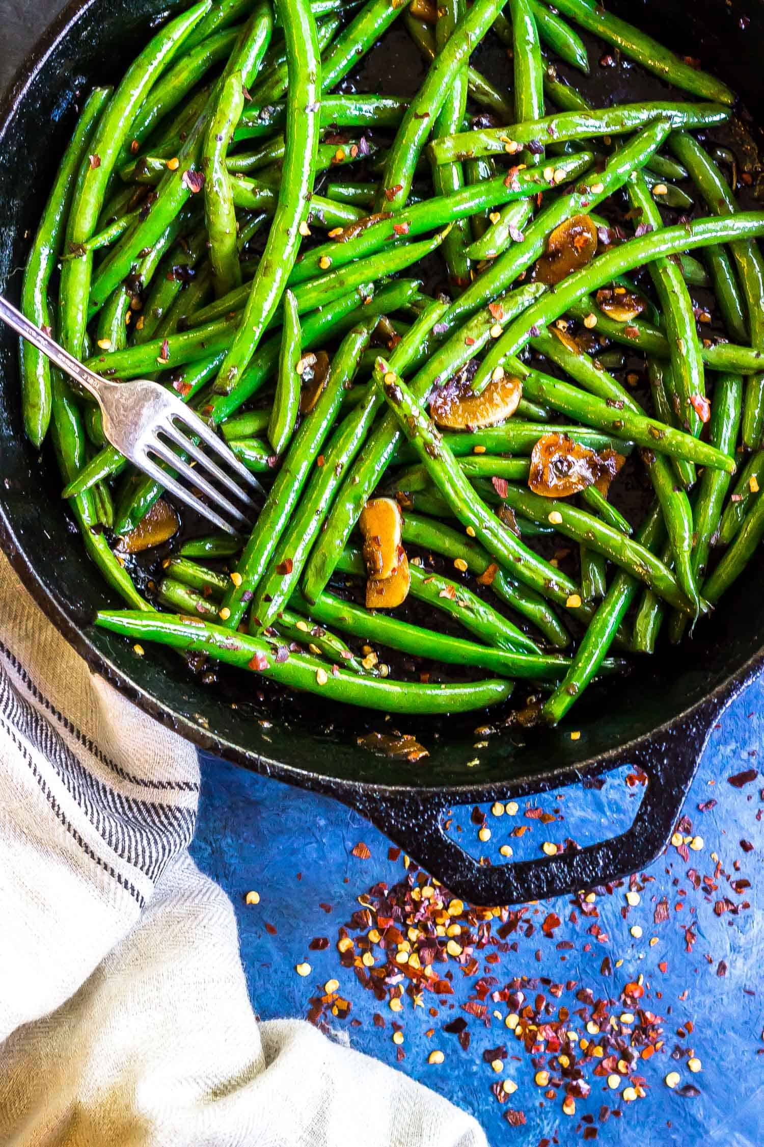 Keto Asian Green Beans in a cast iron skillet with a fork serving