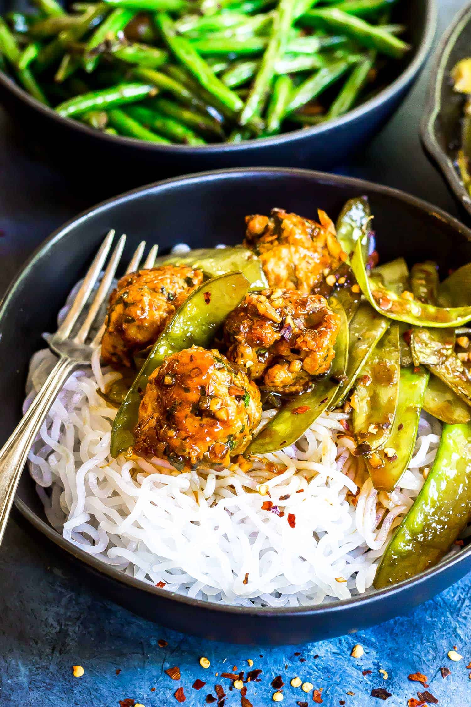 Keto Asian BBQ Meatball Noodle Bowl with Asian green beans in the background
