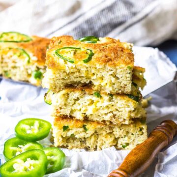 Keto Cornbread with jalapeños and Bacon stacked on a white parchment paper