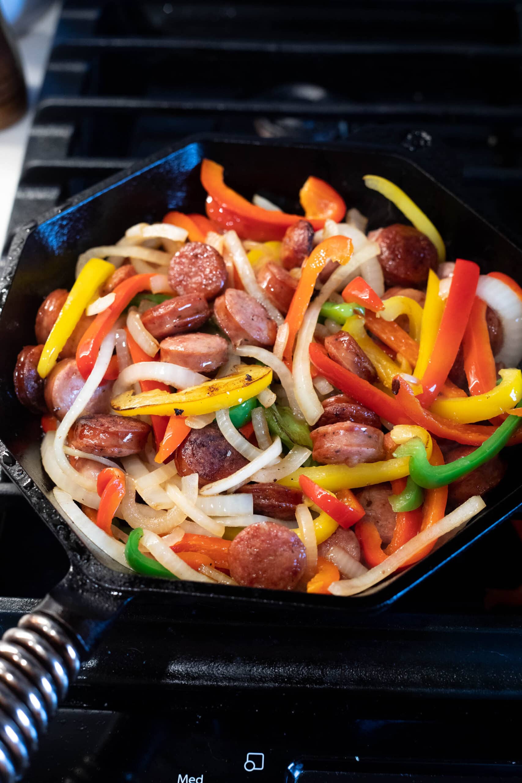 Cast iron skillet filled with peppers onions and sausage