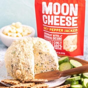 Pepper Jack Cheese Ball on plate with crackers and sliced cucumbers