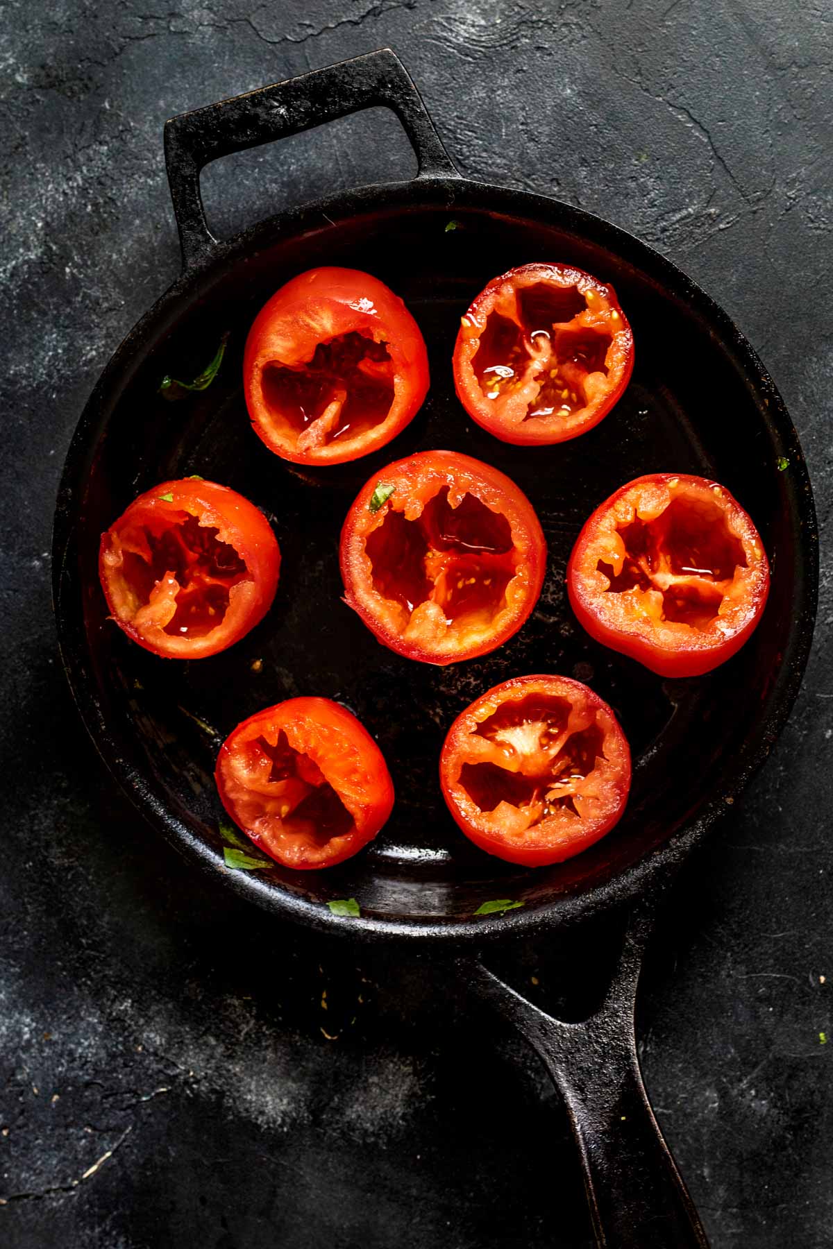 hollowed out tomatoes in a cast iron skillet