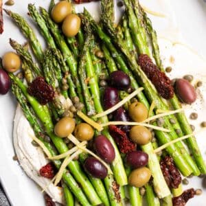 Mediterranean Asparagus - charred lemon garlic asparagus on top of whipped feta and topped with olives, capers, sun-dried tomatoes, and lemon zest.