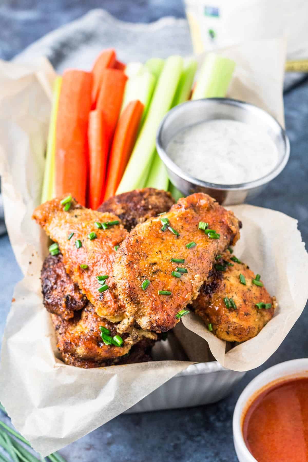 Keto Buffalo Chicken Tenders in a tray with cut fresh veggies and ranch dressing