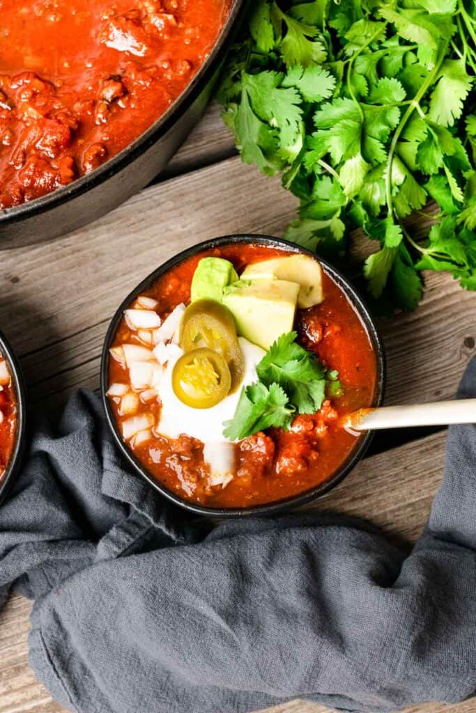 Keto Chorizo Chili in a black bowl with cilantro to the side