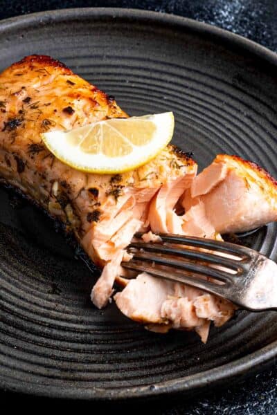 cooked salmon being flaked with fork