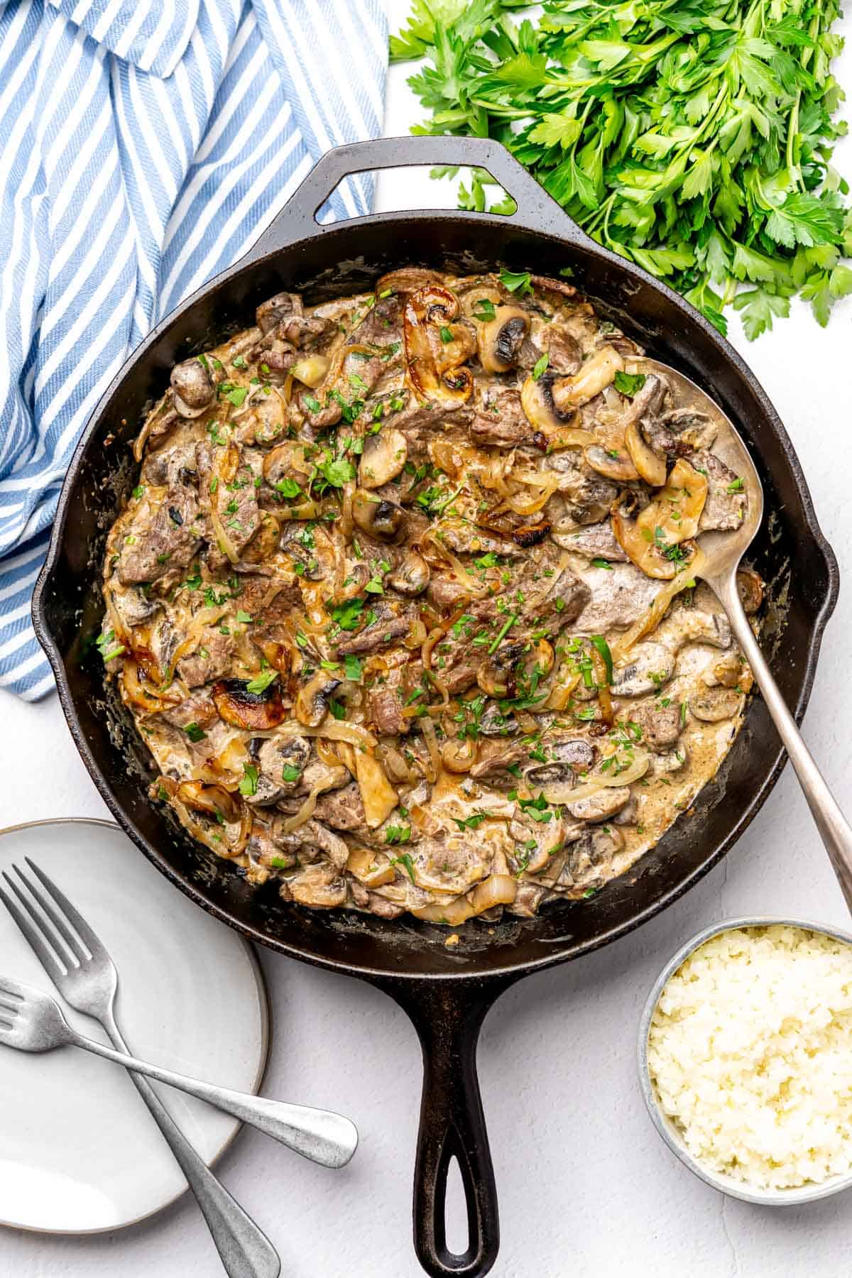 Keto Beef Stroganoff in a cast iron skillet on a white backdrop