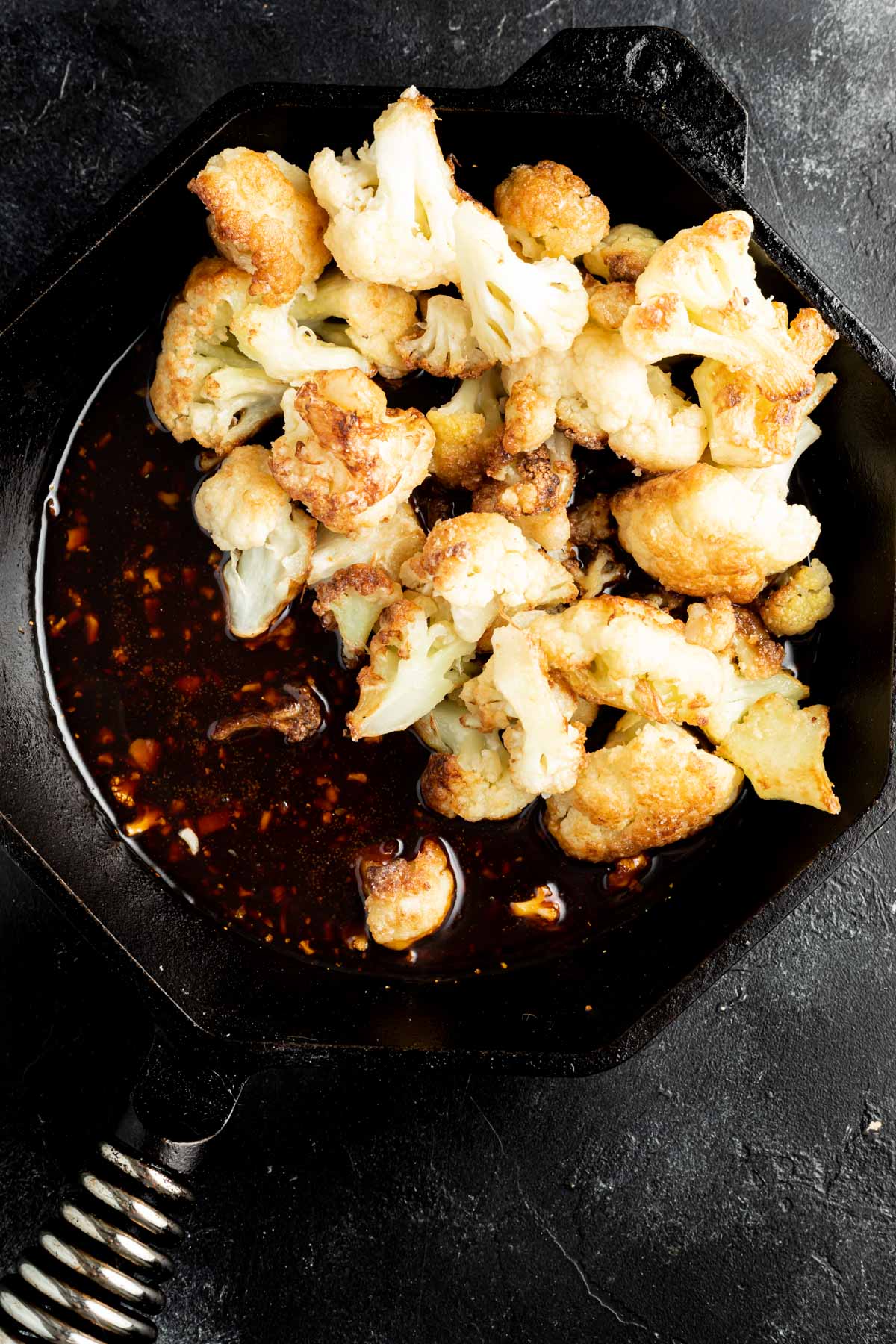 cauliflower being tossed with sesame sauce