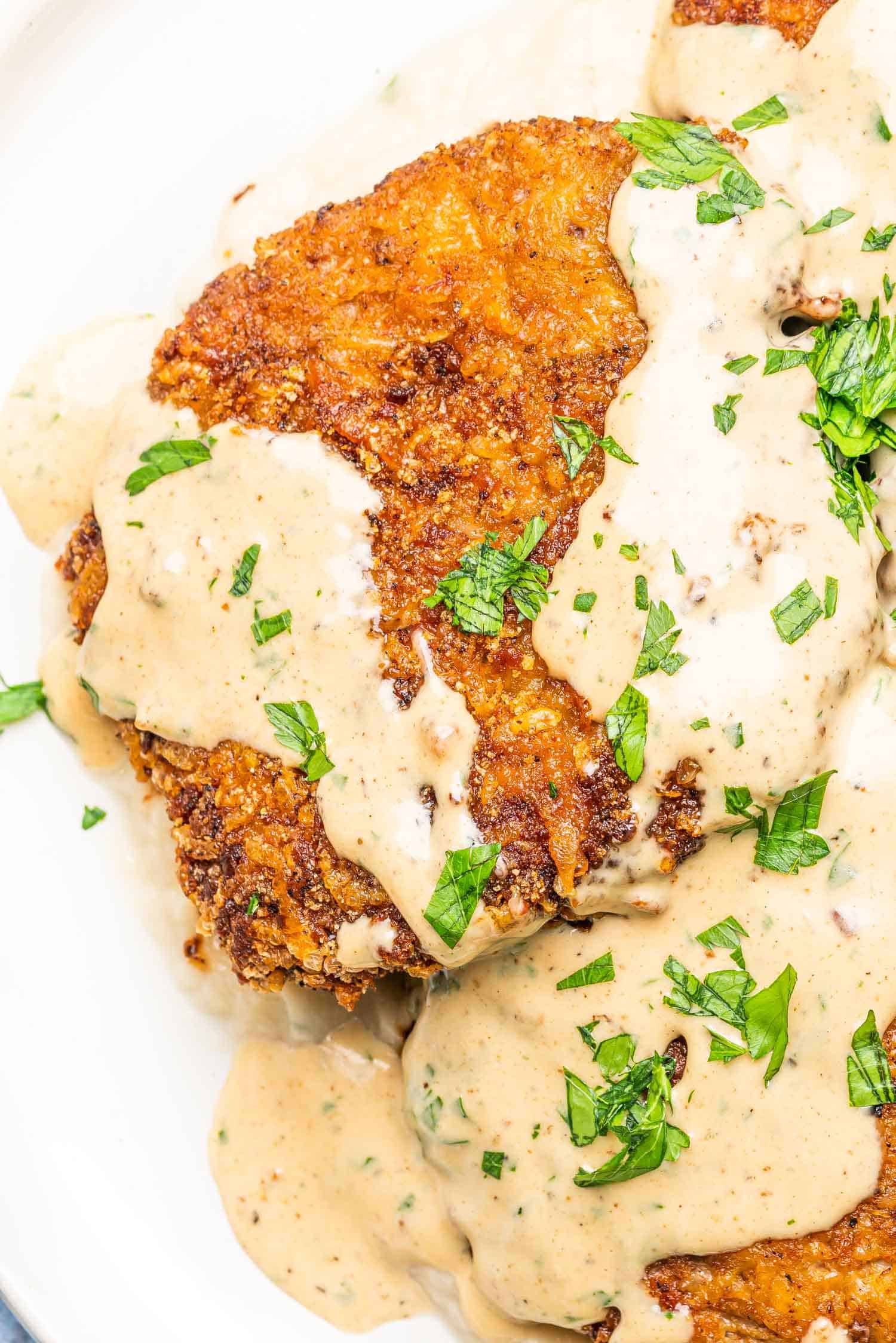 close up of a fried steak cutlet topped with gravy