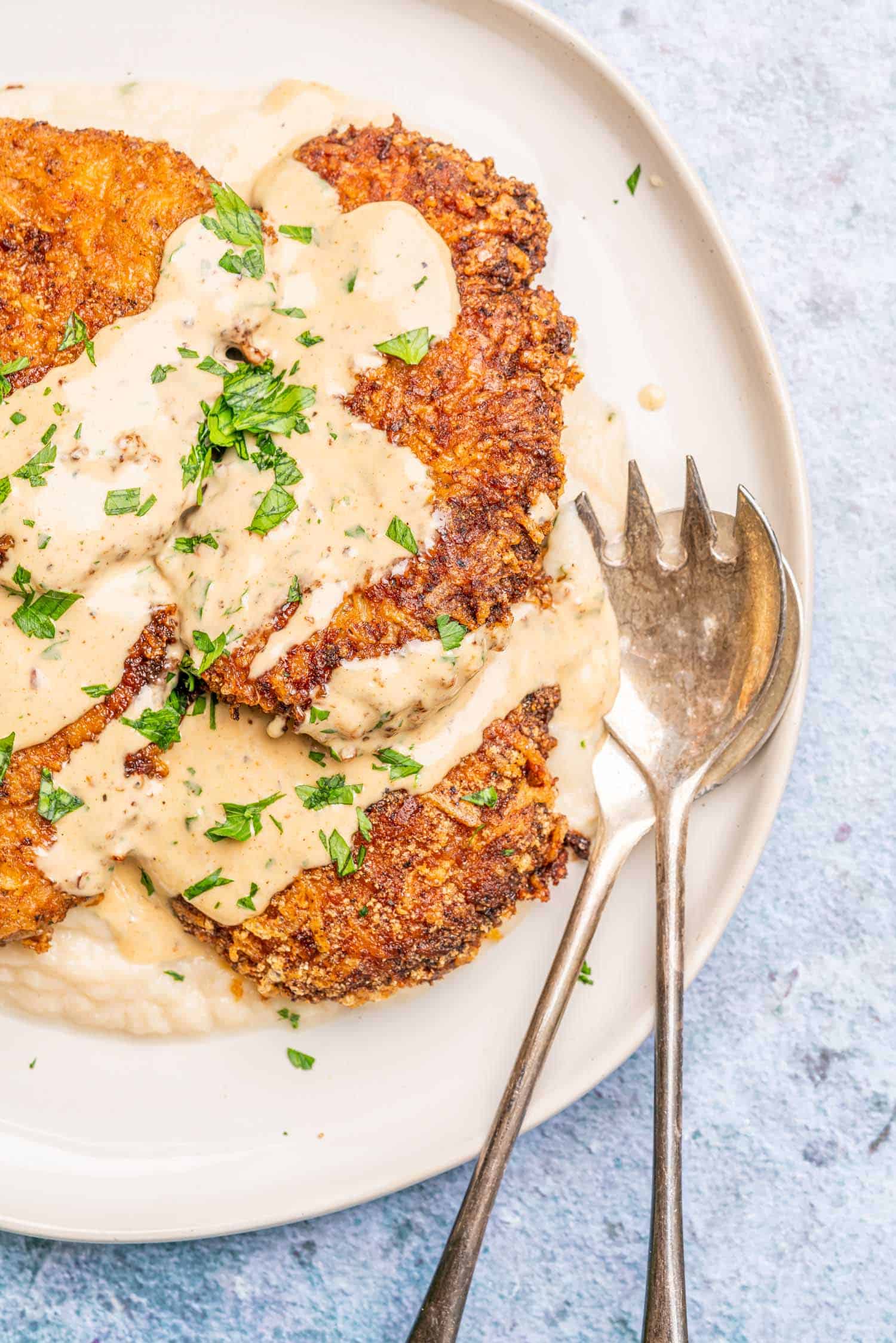 Keto Chicken Fried Steak on a platter with gravy over the top
