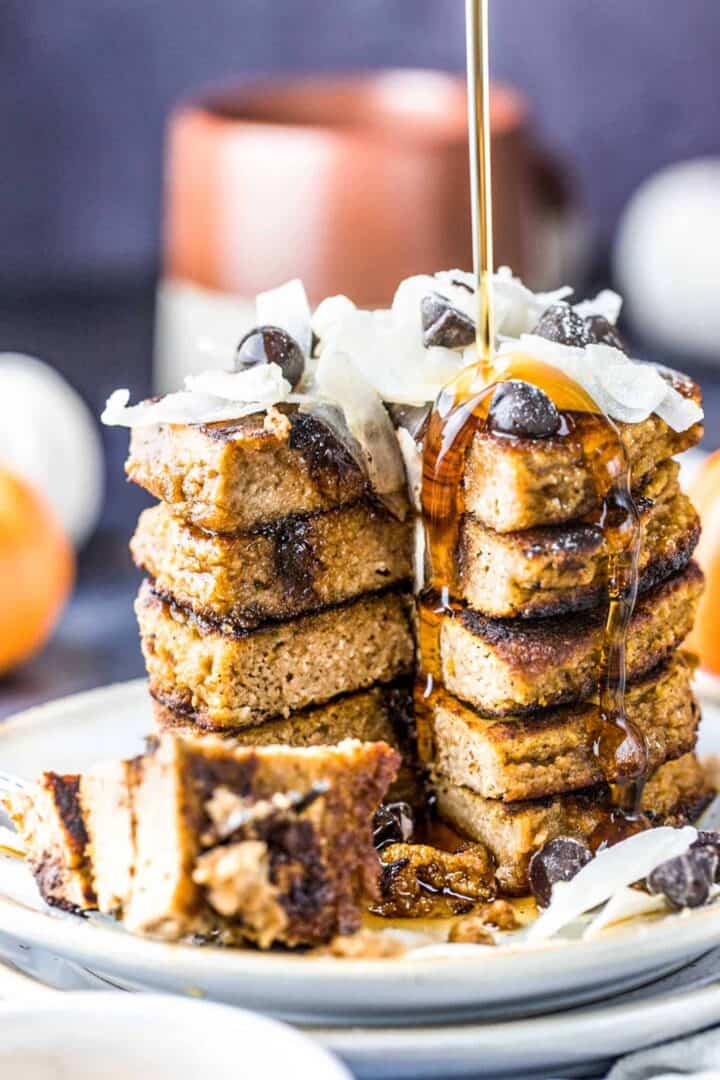 Keto Pumpkin Pancake stack being drizzled with sugar-free maple syrup