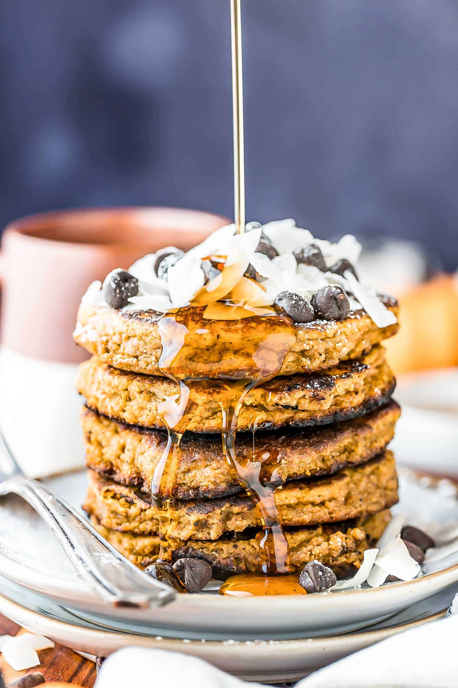 stack of keto pumpkin pancakes with a drizzle of sugar-free maple syrup pouring down the front